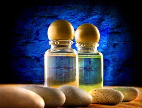 Shampoo bottles with stones on wall background