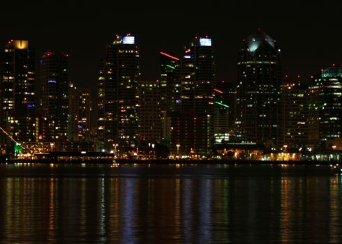 The skyline of San Diego at night with reflection in the water.