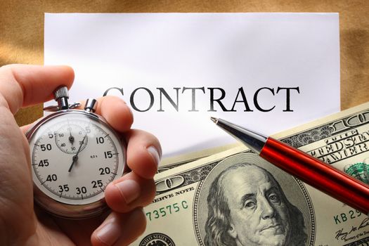 Contract conception with money, pen and hand holding stopwatch