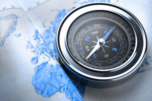 Compass on map background in blue toning