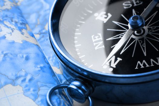 Compass on map background in blue toning