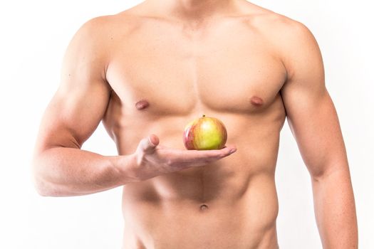 Muscular man toros with apple on hand - studio shoot