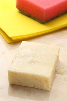 Bar of soap, duster and sponge on tile