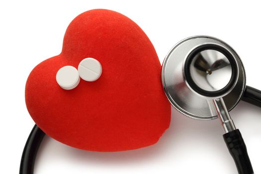 Red heart, stethoscope and pills on white background