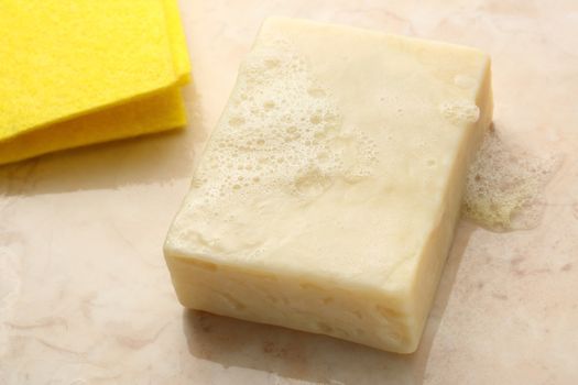 Bar of soap and duster on tile