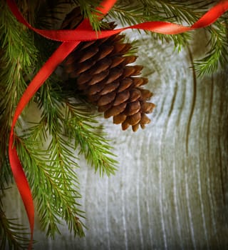 Christmas decoration with fir and cone on wooden background