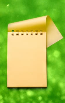 Yellow notepad on green background