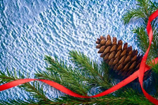 Background with fir and cone on blue snow