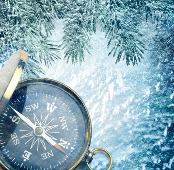 Compass on snow background with fir decoration