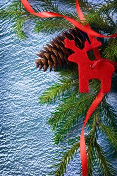 Background with fir, reindeer and cone on blue snow