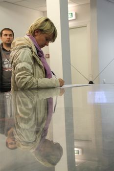 Khimki, Moscow region, Russia - October 14, 2012. Candidate for mayor of Khimki opposition Evgeniya Chirikova writes a complaint about violations at one of the polling stations. On election day in the suburban town of Khimki broke sharp competition between the candidate of the Kremlin Oleg Shahov and representative opposition Yevgenia Chirikova