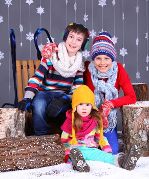 Winter Fashion. Adorable happy boy and girls in winter hat, gloves and sweater in studio.