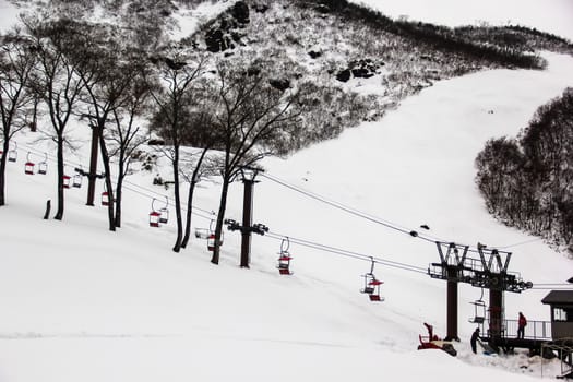 Ski chair lift with skiers on mountain