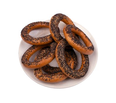 Fresh bagels, sprinkle with poppy seeds on a beige plate isolated on white background