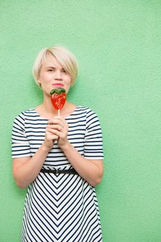 Young sexy woman sucking lollipop. Urban style. Outdoors, lifestyle.