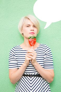 Young sexy woman sucking lollipop. Urban style. Outdoors, lifestyle.