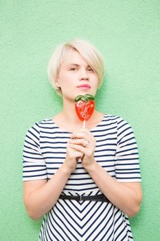 Young sexy woman sucking lollipop. Urban style. Outdoors, lifestyle.