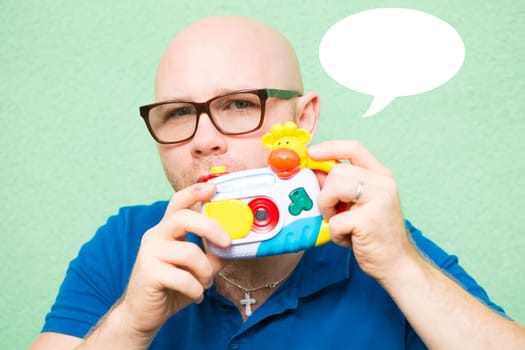 Young man taking photo with toy camera, focus on face