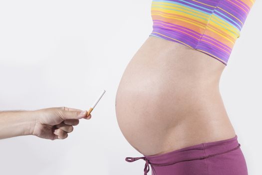 offering cigarette to tummy of naked pregnant woman