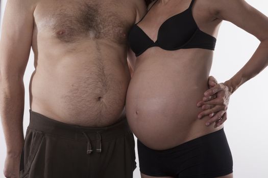 embraced pregnant woman and fat man on white background