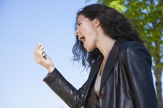 woman shouting in video call smartphone at exterior background