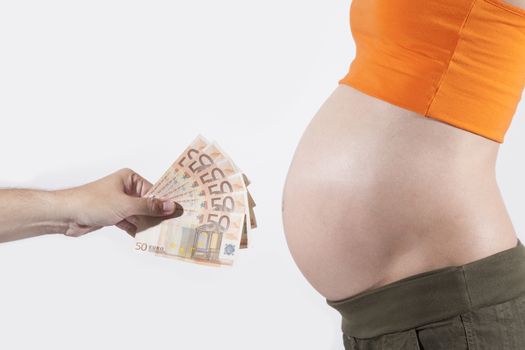 offering Euro banknotes to tummy of naked pregnant woman