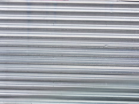 Background Wide shot of silver corrugated metal with bolts