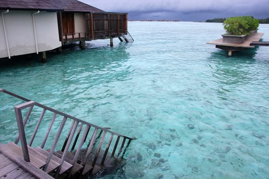 Timber steps down to water from pier resort Maldives