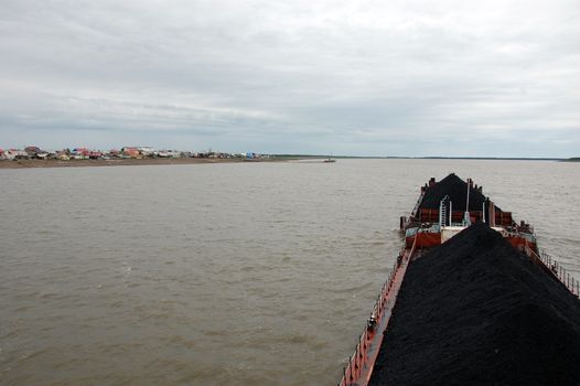 Ship with coal at Kolyma river near village, Yakutia region, Russia