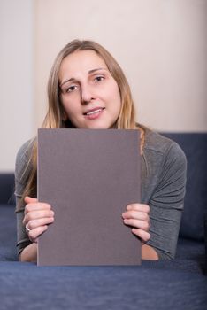 Portrait of elegantly dressed young brunette woman with magazine