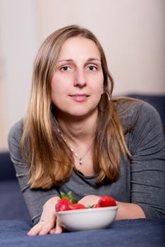 Portrait of young brunette woman with strawberry