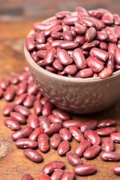 Bowl with red beans close up on wooden table