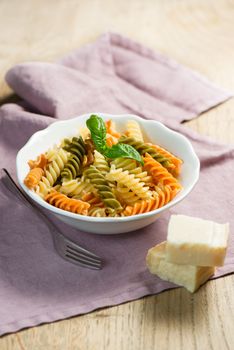 Pasta and basil in a bowl with hard cheese