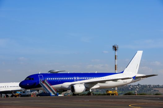 Commercial jet airplane parking at the airport with passenger loader attached, ready for boarding