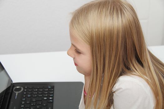 Young Girl Using Laptop At Home