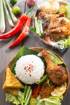 Popular delicious Indonesian local food nasi ayam penyet, indonesian fried chicken rice with sambal belacan. Fresh hot with steam smoke.