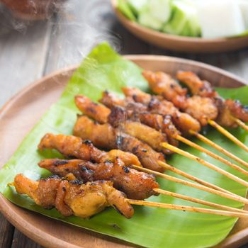Yummy chicken sate or satay, skewered and grilled meat, served with peanut sauce. Fresh cooked with steamed and smoke. Hot and spicy Asian dish. 
