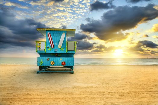 Miami South Beach sunrise with lifeguard tower and coastline with colorful cloud and blue sky. 