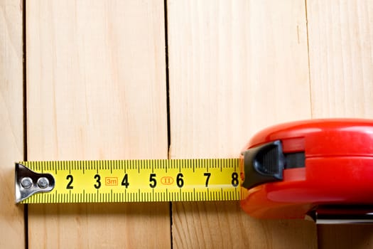 Tape measure on wooden background