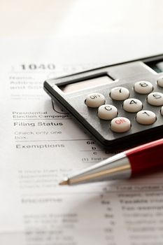 Tax form, red pen and calculator 