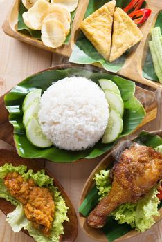 Famous traditional Indonesian food. Delicious nasi ayam penyet with sambal belacan. Fried chicken rice and tea with overhead view.