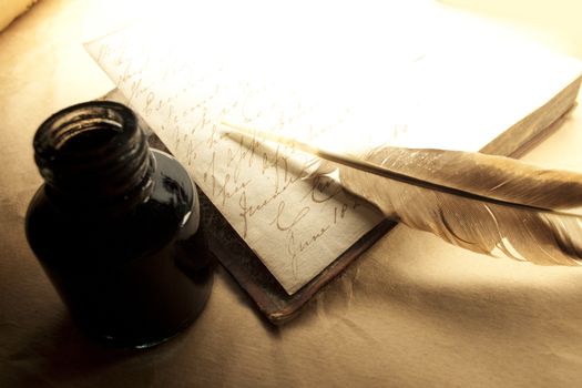 Old book with feather and inkpot 