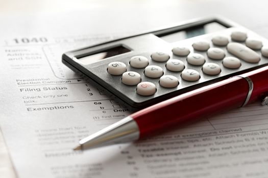 Tax form, red pen and calculator 