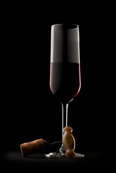 Glass of red wine with corkscrew