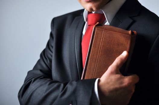 Businessman in a suit holding a book