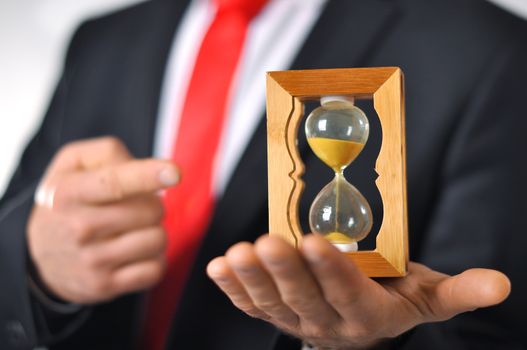 Man in a suit with tie holding an hourglass