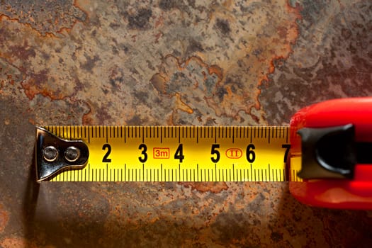 Tape measure on the rusty background