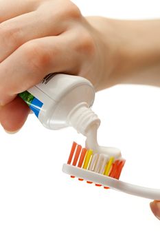 Toothbrush and toothpaste in female hands