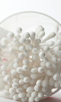 White cotton swabs in plastic container