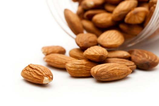 Almonds in the plastic jar on white 